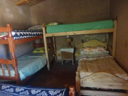 a bedroom with two bunk beds and a table at Casa de Campo Clarita y Hector in Ovara