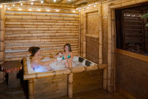 two people in a bath tub in a log cabin at Cabaña Manantial del Turpial in Jardin