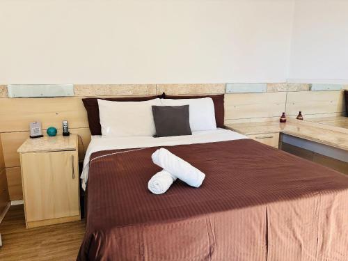 a bedroom with a large bed with two towels on it at Morada Supreme Flat Jardim Europa II in Sao Paulo
