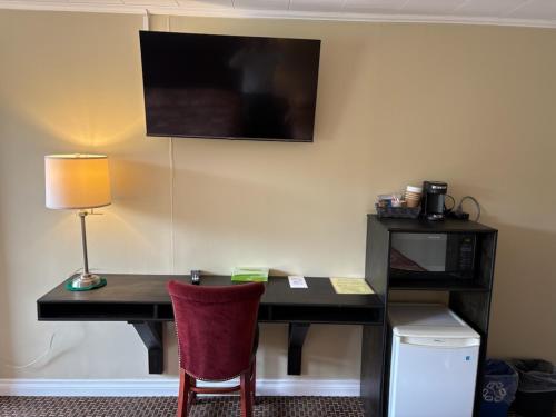 a desk with a lamp and a chair in a room at Pioneer Inn by the River in Port Hardy
