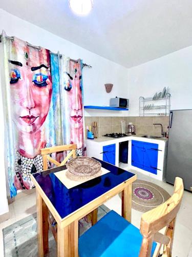 a small kitchen with a table and a kitchen with blue cabinets at Amnesia Residence in Naama Bay - Downtown in Sharm El Sheikh