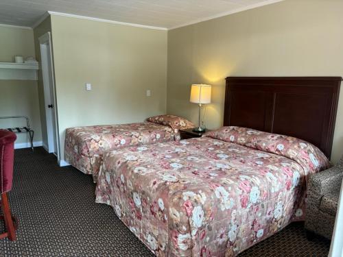 a hotel room with two beds and a lamp at Pioneer Inn by the River in Port Hardy