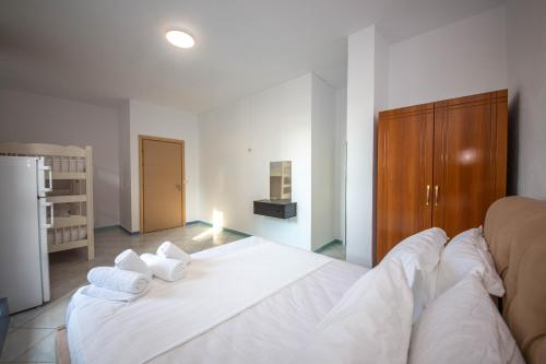 a bedroom with a white bed with towels on it at Noemi's Hotel Ksamil in Ksamil