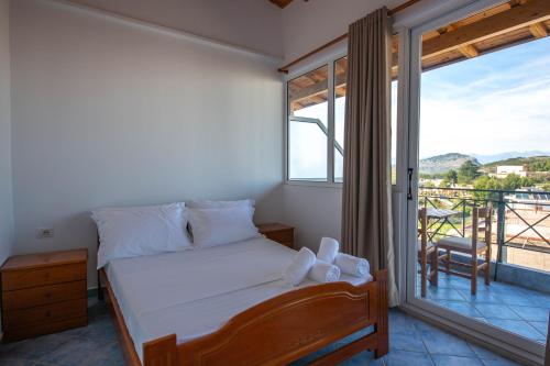 a bedroom with a bed and a balcony at Noemi's Hotel Ksamil in Ksamil
