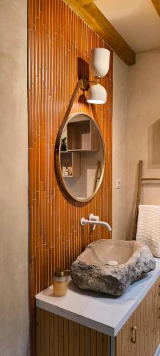 a bathroom with a round mirror and a sink at AMEIO - Country House in Rio Maior