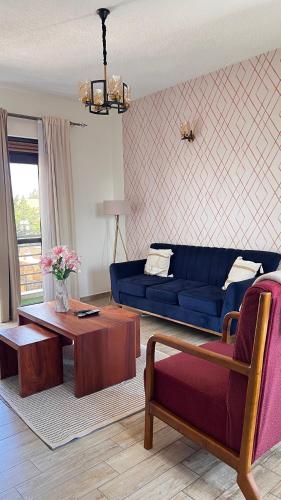 a living room with a blue couch and a table at Silver Homes Ug K05 in Kampala