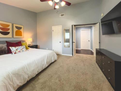 a bedroom with a large bed and a flat screen tv at Plano Family Haven Cozy & Close To Everything! in Plano