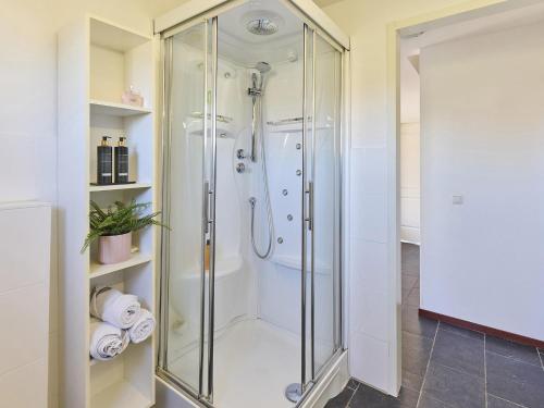 a shower with a glass door in a bathroom at Farmhouse in Limburg near Maasplassen in Roggel