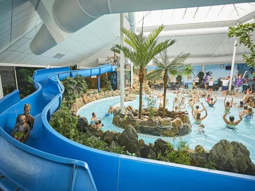 a water slide at a resort with people in a pool at Farmhouse in Limburg near Maasplassen in Roggel