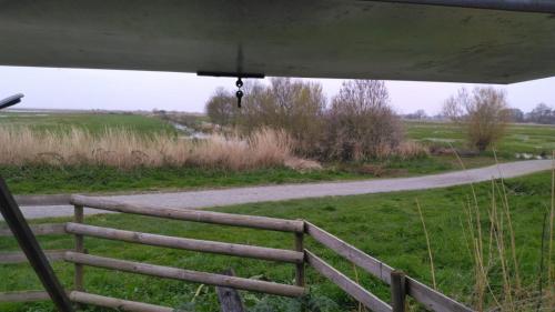 une vue sur un champ avec une clôture et une route dans l'établissement Les pêcheries Jumelles, à Saint-Malo-de-Guersac