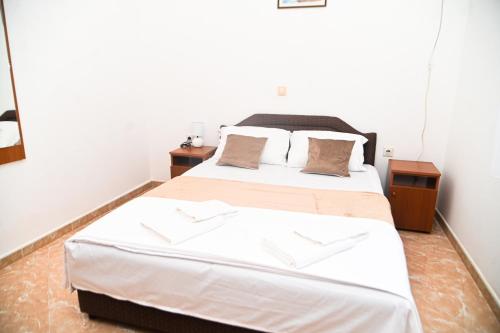 a bedroom with a large bed and two night stands at Antonios Apartments in Ulcinj