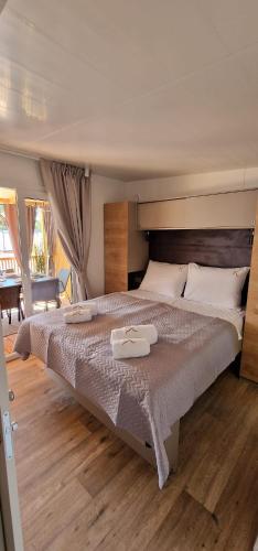a bedroom with a large bed with two trays on it at Mobile home K in Biograd na Moru