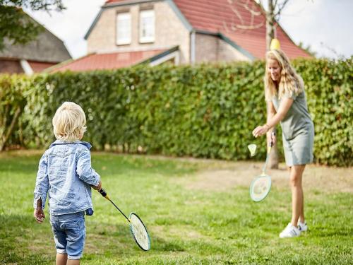 a woman and a little boy playing with tennis rackets at Farmhouse in Limburg with Subtropical Pool in Roggel