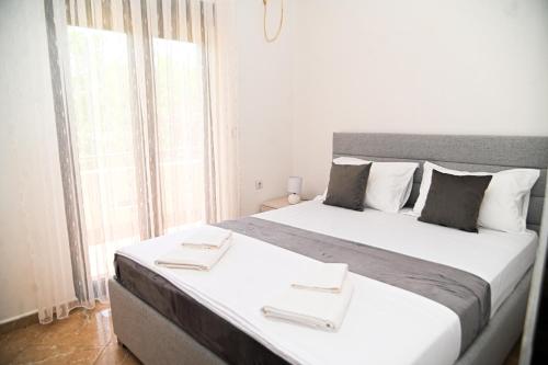 a large bed in a room with a large window at Antonios Apartments in Ulcinj