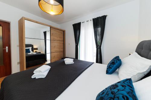 a bedroom with a large bed with towels on it at Apartmani Riva in Zadar