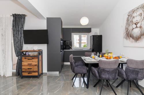 a kitchen and dining room with a table and chairs at Apartmani Riva in Zadar