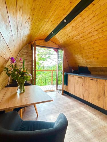 Cette chambre en bois comprend une table et un vase de fleurs. dans l'établissement La cabane entre les cimes, 