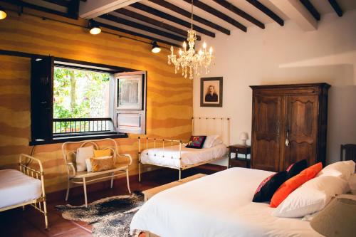 a bedroom with two beds and a chandelier at Finca Boutique el Diamante in Salgar