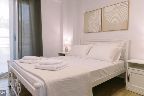 a bedroom with a white bed with towels on it at GMhouse in Perdika