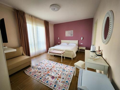 a small bedroom with a bed and a table at Vila Ermoza in Korçë