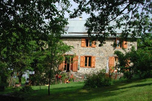 a large stone house with trees in front of it at Le Gîte des Fées in Crévoux in Crévoux