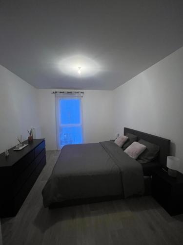 - une chambre avec un lit et une fenêtre bleue dans l'établissement Appartement cosy vue sur Seine, à Alfortville