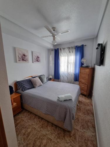 ein Schlafzimmer mit einem Bett und einem Fernseher darin in der Unterkunft Amanecer Costero in Orihuela