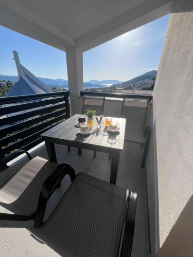 a table and chairs on a balcony with a view at Apartman Ante in Neum