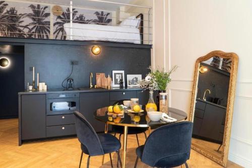 une salle à manger avec une table, des chaises et un miroir dans l'établissement Suite Amalfi - Check in h24 - Wifi, à Lyon