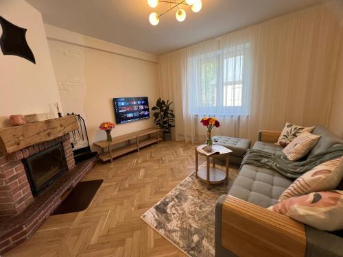 a living room with a couch and a fireplace at ATK Apartment T1 Airport Bus Station in Tallinn