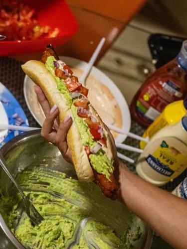 a person holding a hot dog in their hand at Hostel Hasta La Vista in Sarandë