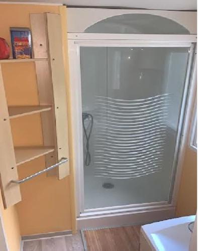 une porte en verre d'un réfrigérateur dans la cuisine. dans l'établissement Mobil home paisible, à Saint-Chéron