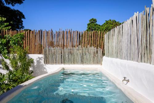 a swimming pool in front of a wooden fence at Vila Santo Rei Trancoso in Trancoso