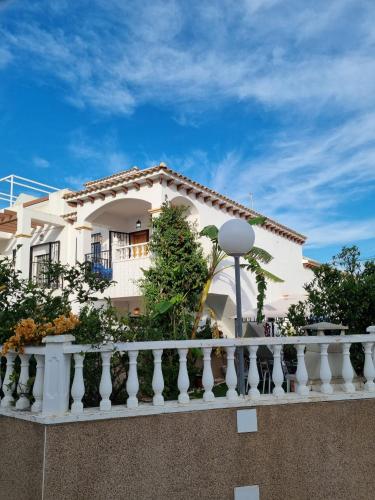ein weißes Gebäude mit einem weißen Geländer auf dem Balkon in der Unterkunft Amanecer Costero in Orihuela