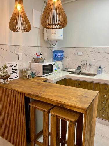 a kitchen with a counter top with a microwave at Aloha Nelly - Departamento de alquiler por día in Trelew