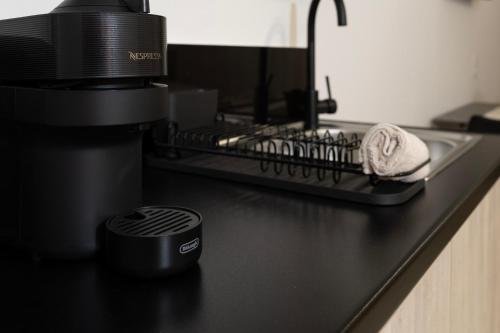 a black counter top with a coffee maker and towels at NS Apartments Nydri in Nydri