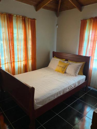 a bed with white sheets and yellow pillows in a room at Beach View in Corinthe