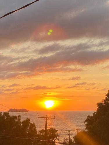 a sunset over the ocean with the sun in the sky at Beach View in Corinthe