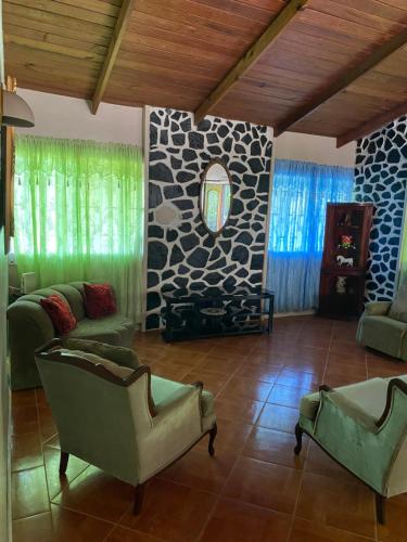 a living room with green furniture and a stone wall at Beach View in Corinthe