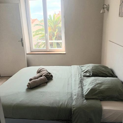 - un lit avec une serviette et une fenêtre dans l'établissement Le Baya - Appt proche des Halles, à Narbonne