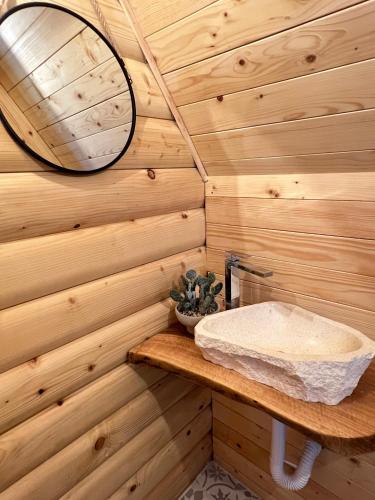 a bathroom with a sink in a wooden wall at Grlo Sokolovo A-Frame Cottage - Mountain Retreat near Podgorica in Korita