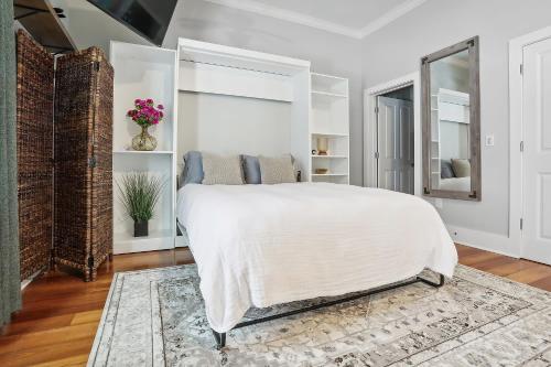 a bedroom with a white bed and a mirror at 1 bedroom home In Baton Rouge La in Baton Rouge