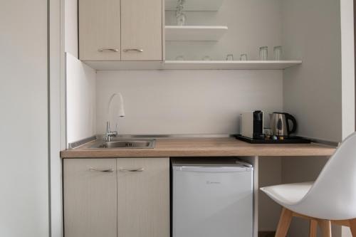 a small kitchen with white cabinets and a sink at Villa Paraschou in Neos Marmaras