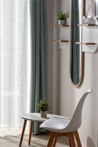 a white chair sitting next to a window with a mirror at Villa Paraschou in Neos Marmaras