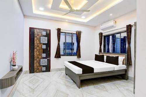 a bedroom with a bed and two windows at Hotel O Sunshine in Sāntrāgāchi
