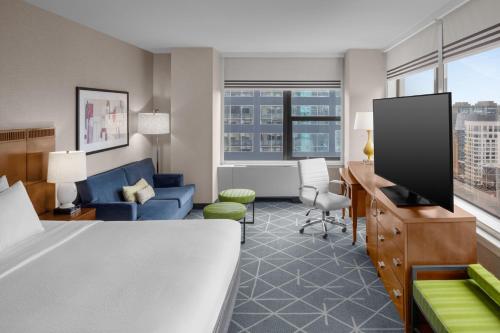 a hotel room with a bed and a tv at Courtyard New York Manhattan/Midtown East in New York