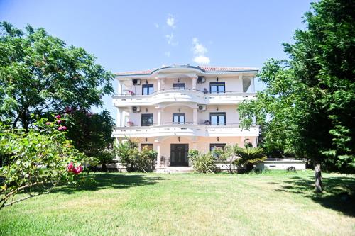 a large white building with a yard in front of it at Antonios Apartments in Ulcinj