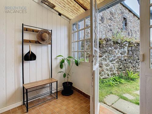 un portico con panchina e muro di pietra di Maison Ty Gwen - Centre-ville avec jardin et proche de la plage a Crozon