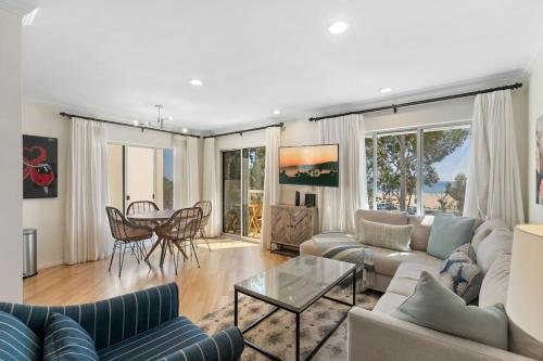 a living room with a couch and a table at The Andalusite - Oceanfront Steps from the Sand in Los Angeles