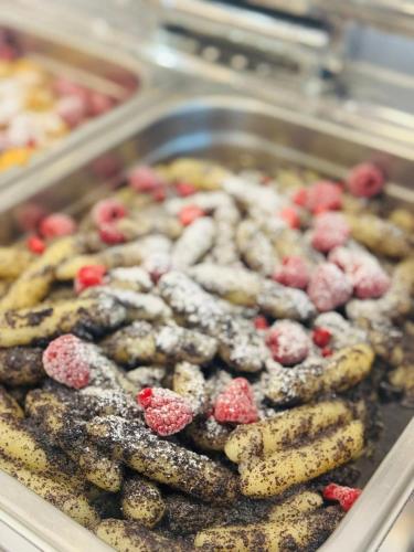 a tray of cookies with raspberries on top of them at Hotel Lesana in Vysoké Tatry